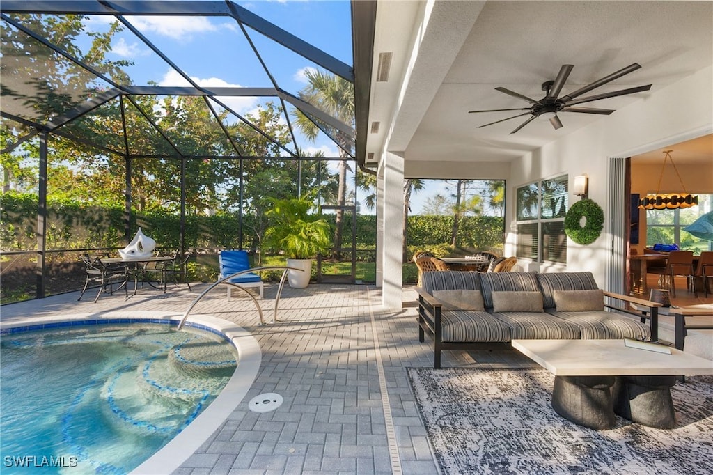 exterior space featuring an outdoor living space, ceiling fan, glass enclosure, and a patio area