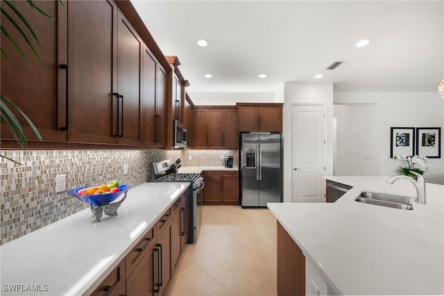 kitchen with sink, light tile patterned floors, stainless steel appliances, tasteful backsplash, and dark brown cabinetry