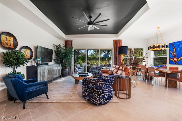 living room with a wealth of natural light, a raised ceiling, and light tile patterned floors