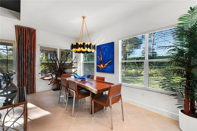 tiled dining area with a wealth of natural light and an inviting chandelier