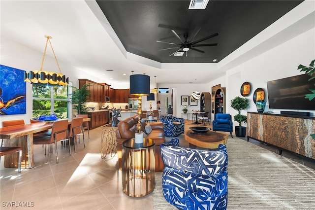 tiled living room featuring a tray ceiling and ceiling fan