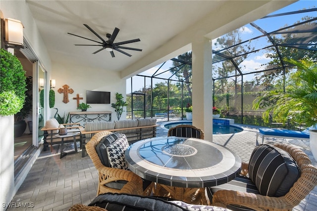 view of patio featuring ceiling fan, exterior bar, an outdoor hangout area, and glass enclosure