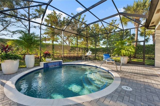 view of swimming pool featuring a lanai, pool water feature, and a patio area