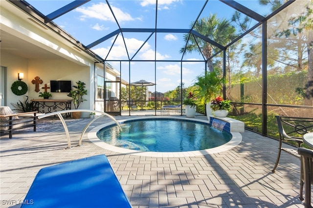 view of pool with a patio, pool water feature, glass enclosure, and a jacuzzi