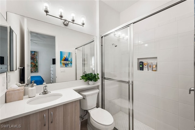 bathroom with vanity, toilet, and a shower with door