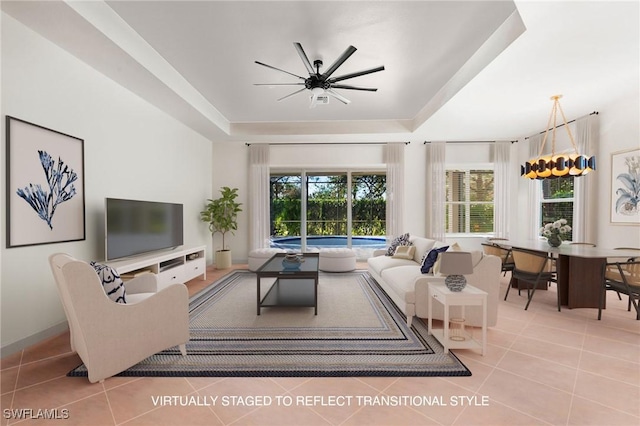 tiled living room featuring a tray ceiling and ceiling fan