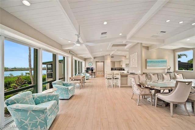 interior space with lofted ceiling with beams, ceiling fan, and light wood-type flooring