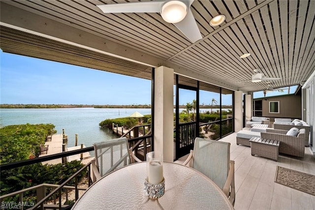 view of patio / terrace with outdoor lounge area, a water view, and ceiling fan