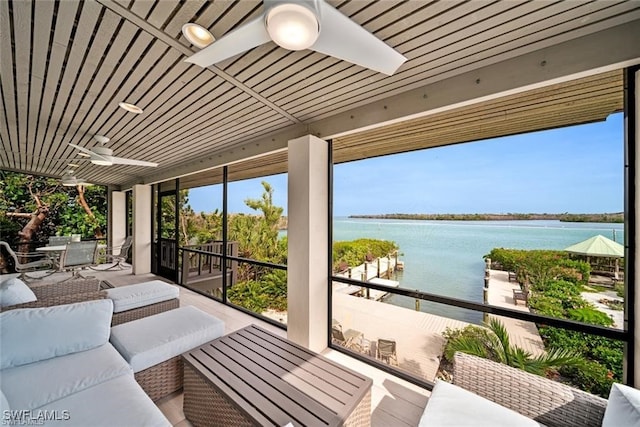 sunroom / solarium with ceiling fan, a water view, and wood ceiling