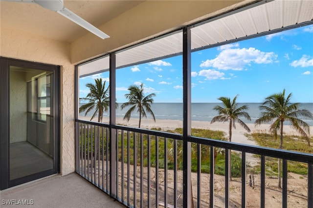 sunroom with a water view and a view of the beach