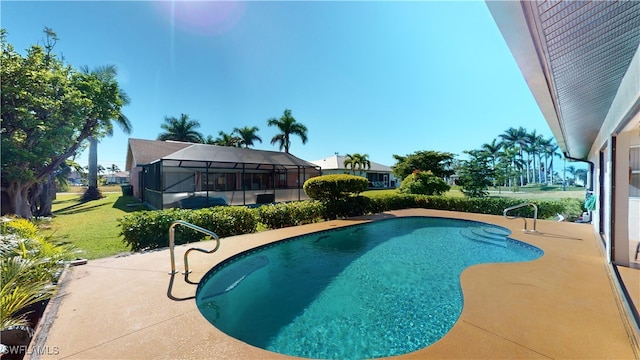 view of pool featuring glass enclosure, a patio area, and a yard