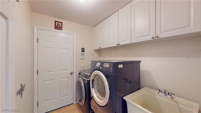 washroom with washing machine and dryer, sink, light tile patterned flooring, and cabinets