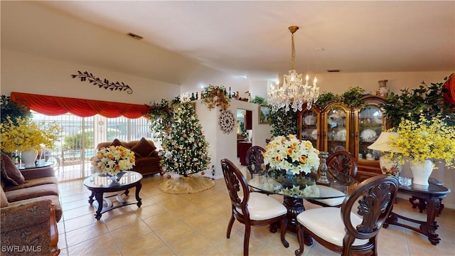 dining space with light tile patterned flooring, a chandelier, and lofted ceiling