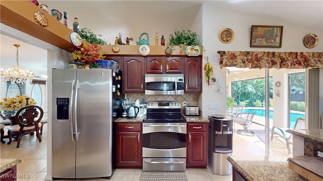 kitchen with lofted ceiling, backsplash, an inviting chandelier, hanging light fixtures, and stainless steel appliances