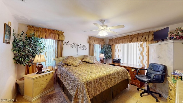 tiled bedroom with multiple windows and ceiling fan