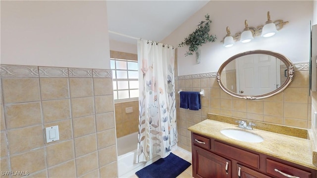 bathroom featuring shower / bath combination with curtain, tile walls, and vanity