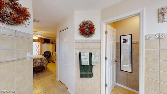 corridor featuring light tile patterned floors and tile walls