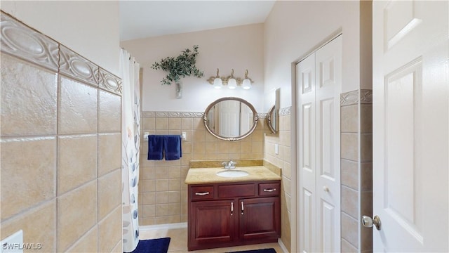 bathroom with tile patterned flooring, vanity, a shower with shower curtain, and tile walls