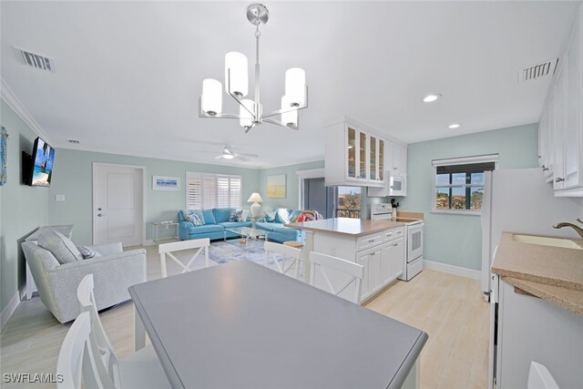 kitchen with a healthy amount of sunlight, white cabinetry, white appliances, and sink