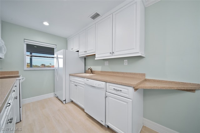 kitchen featuring light wood-type flooring, white appliances, white cabinetry, and sink