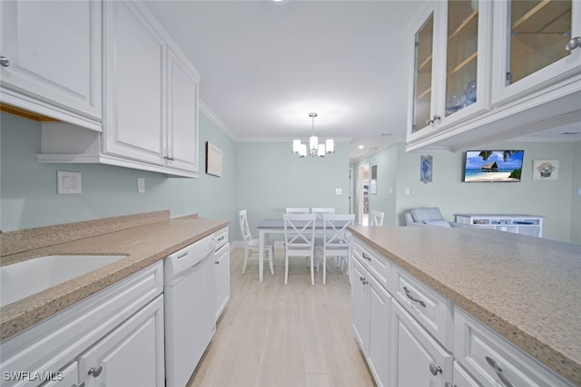 kitchen featuring light wood-type flooring, ornamental molding, white dishwasher, white cabinetry, and hanging light fixtures