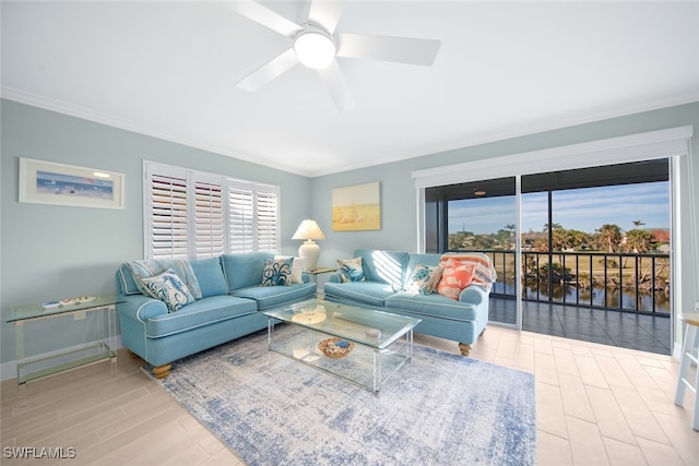 living room featuring ceiling fan, a water view, hardwood / wood-style flooring, and ornamental molding