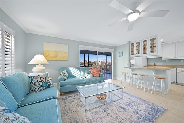 living room with light wood-type flooring, ceiling fan, and crown molding