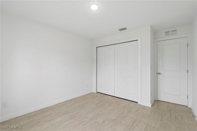 unfurnished bedroom with light hardwood / wood-style floors and a closet