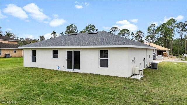 rear view of property featuring a yard and central AC unit