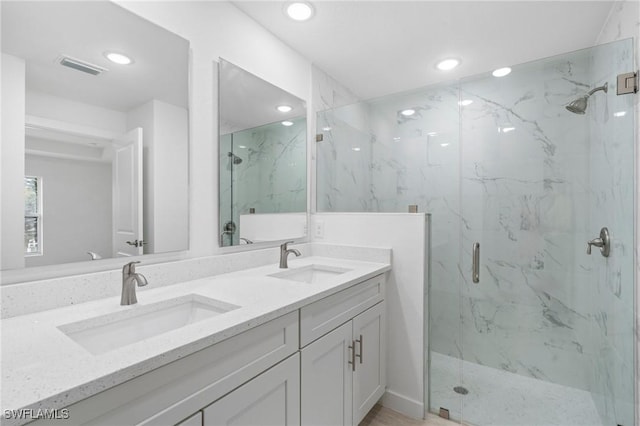 bathroom with vanity and a shower with shower door