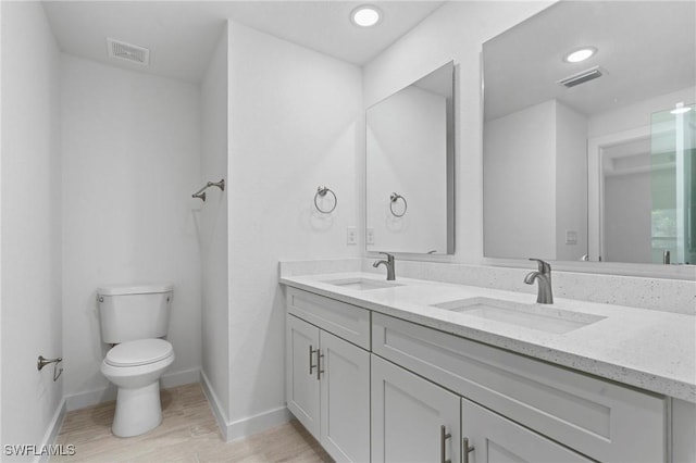 bathroom with toilet, vanity, and hardwood / wood-style flooring