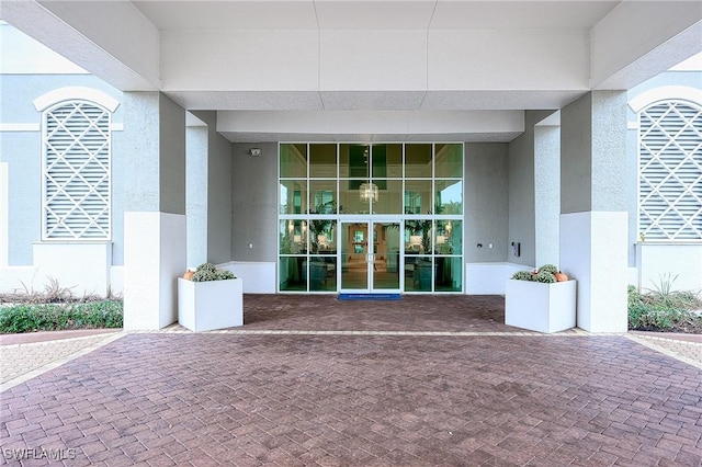 view of exterior entry with stucco siding and french doors