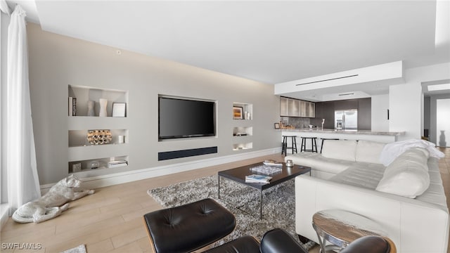 living room featuring light hardwood / wood-style floors and sink