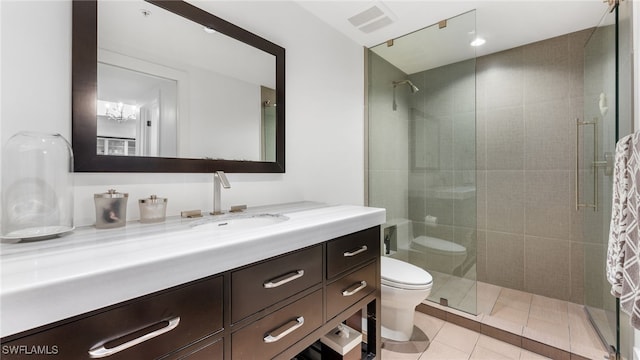 bathroom with tile patterned flooring, a shower stall, toilet, and vanity