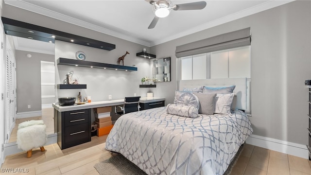 bedroom featuring light wood finished floors, baseboards, ornamental molding, built in study area, and a ceiling fan