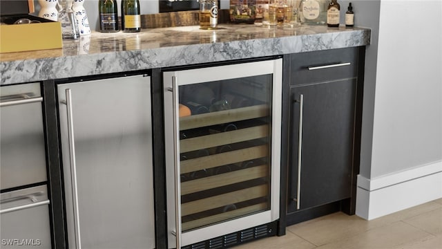 bar with wine cooler, a bar, and tile patterned flooring