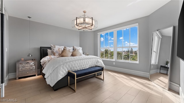 bedroom featuring light hardwood / wood-style floors and a notable chandelier