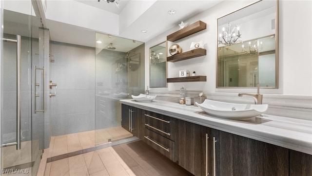 bathroom with vanity, an enclosed shower, and a chandelier