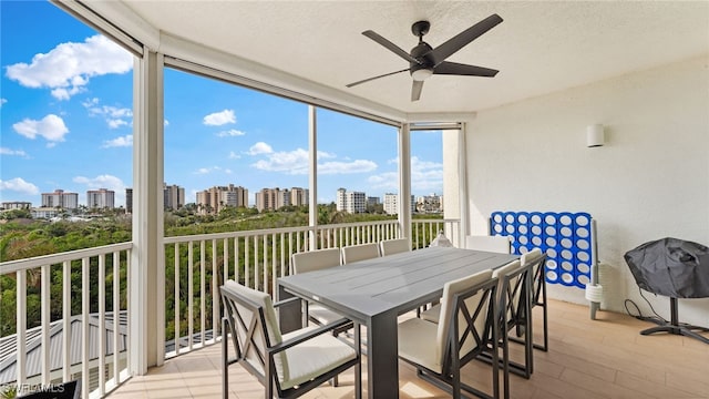 sunroom with a city view and a ceiling fan