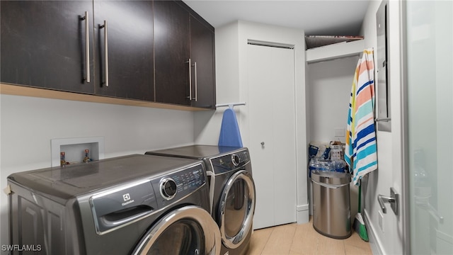 washroom with washer and clothes dryer and cabinet space