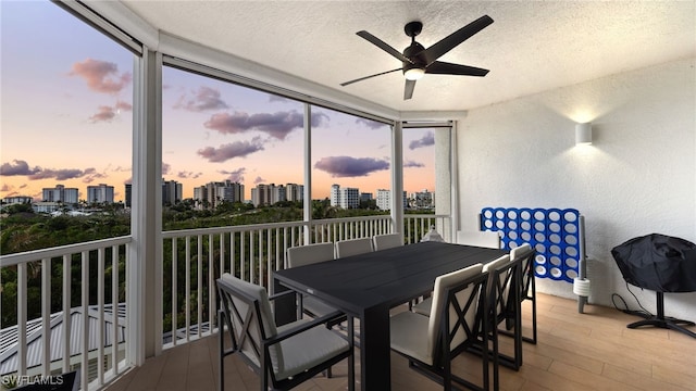 sunroom featuring a view of city and a ceiling fan