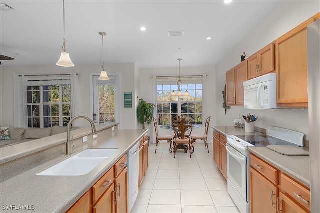 kitchen featuring light tile patterned floors, white appliances, decorative light fixtures, and sink