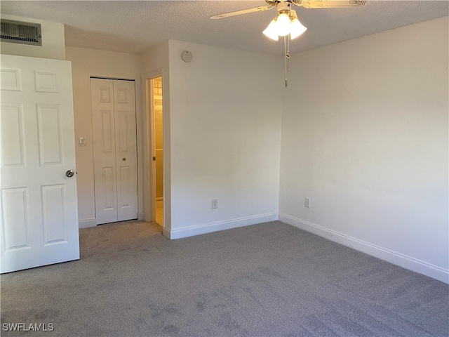 unfurnished room featuring ceiling fan, carpet floors, and a textured ceiling