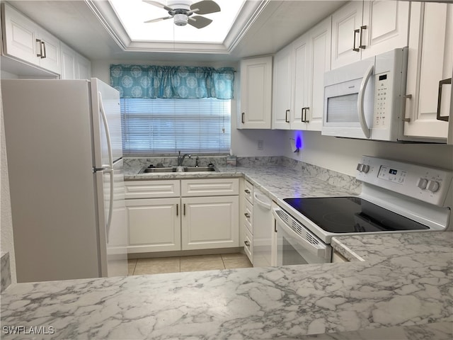 kitchen with white appliances, ceiling fan, sink, light tile patterned floors, and white cabinetry