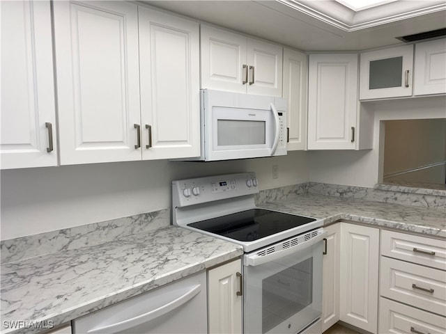 kitchen with light stone countertops, white appliances, and white cabinetry