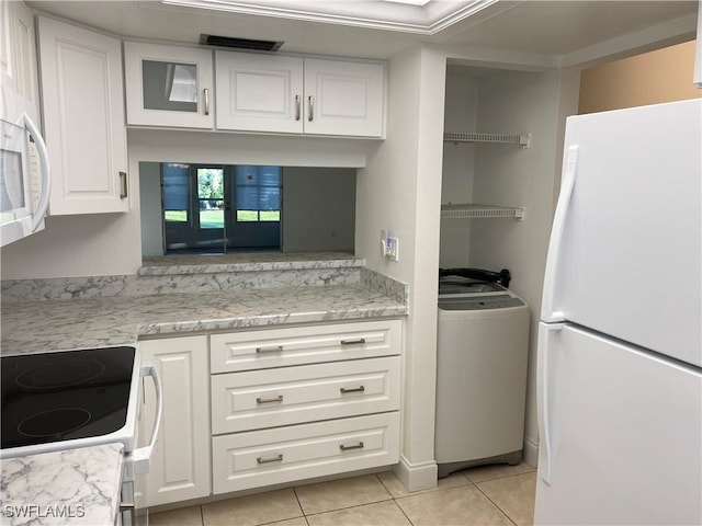 7050 Nantucket Cir Unit 4, North Fort Myers, FL 33917 - kitchen with white appliances, washer / dryer, light tile patterned floors, white cabinets, and light stone counters