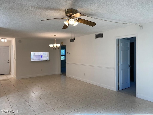 7050 Nantucket Cir Unit 4, North Fort Myers, FL 33917 - spare room featuring a textured ceiling, ceiling fan, light tile patterned flooring, a chandelier, and baseboards