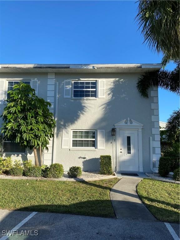 7050 Nantucket Cir Unit 4, North Fort Myers, FL 33917 - view of front facade featuring stucco siding and a front yard