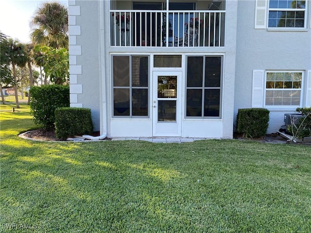 7050 Nantucket Cir Unit 4, North Fort Myers, FL 33917 - view of exterior entry featuring stucco siding and a yard