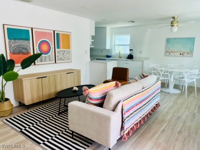 living room featuring light hardwood / wood-style flooring and ceiling fan